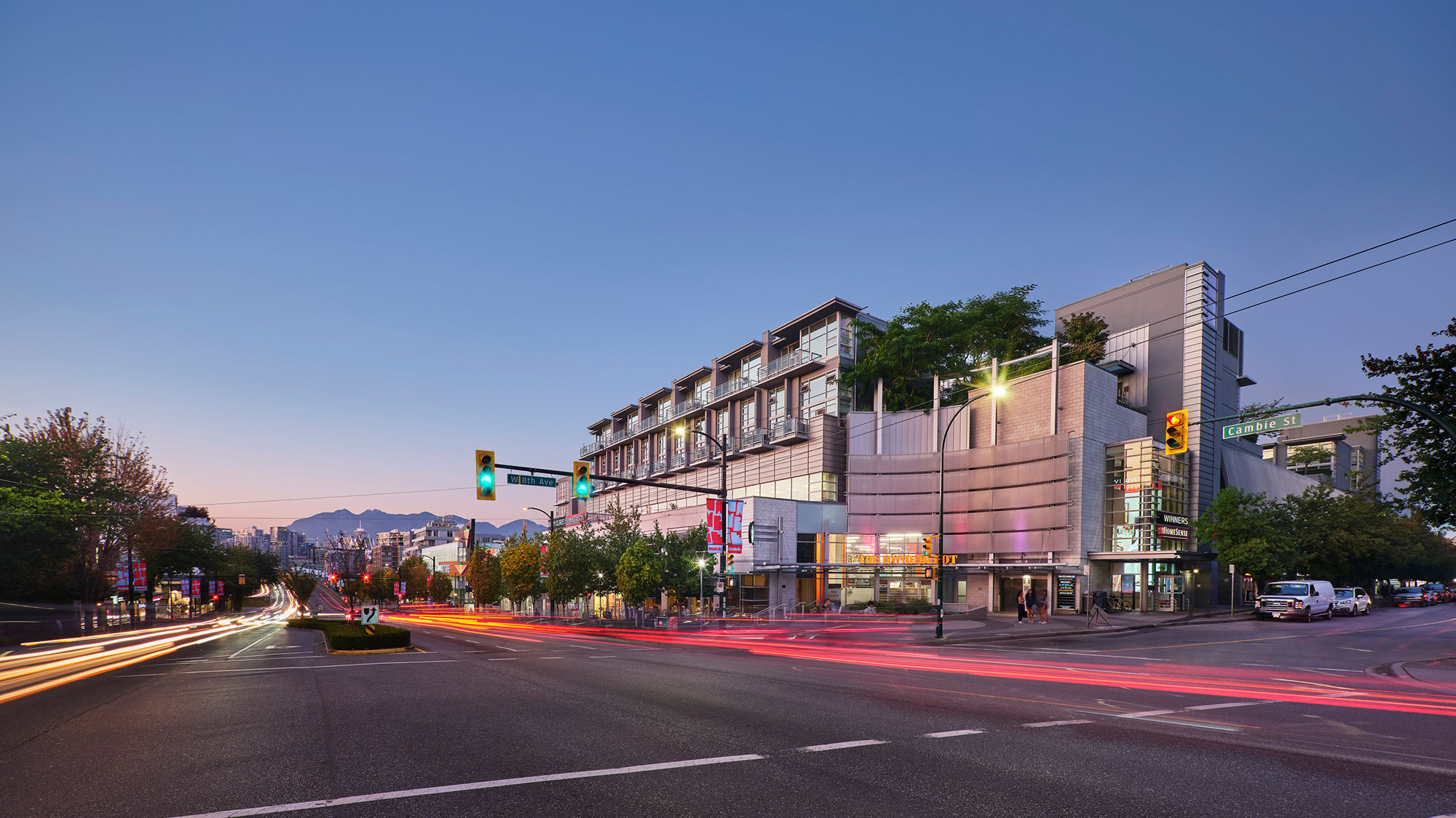 A sidewalk view of the busy streets of 8th Avenue at sunset