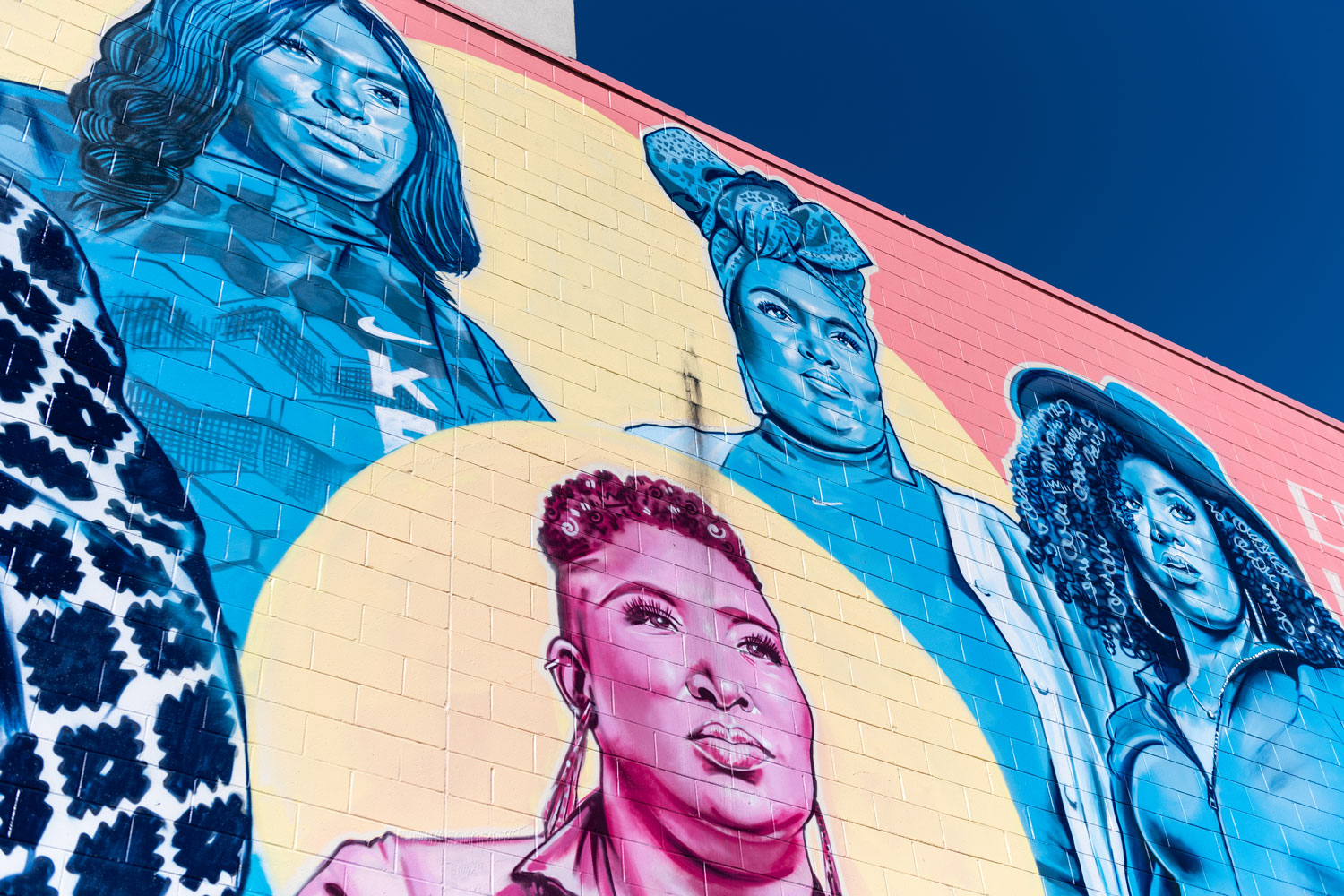 A colorful large cultural mural painted on the side of a building